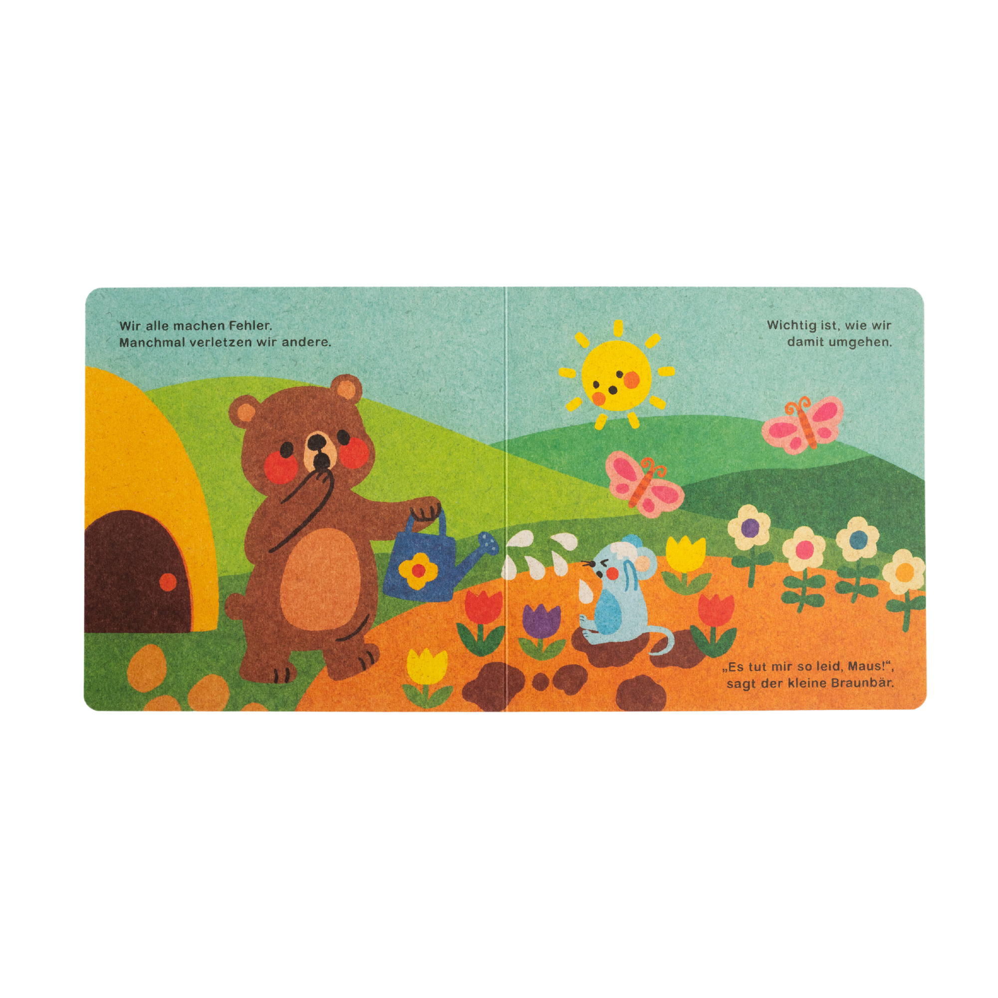 Das illustrierte Kinderbuch "Hilfe brauchen ist ok" von Annelies Draws zeigt einen Braunbären mit einer Gießkanne neben einem Bienenstock, Blumen und einer blauen Maus. Die Szene entfaltet sich im Sonnenschein mit Wolken, Schmetterlingen und deutschem Text am oberen und unteren Rand.